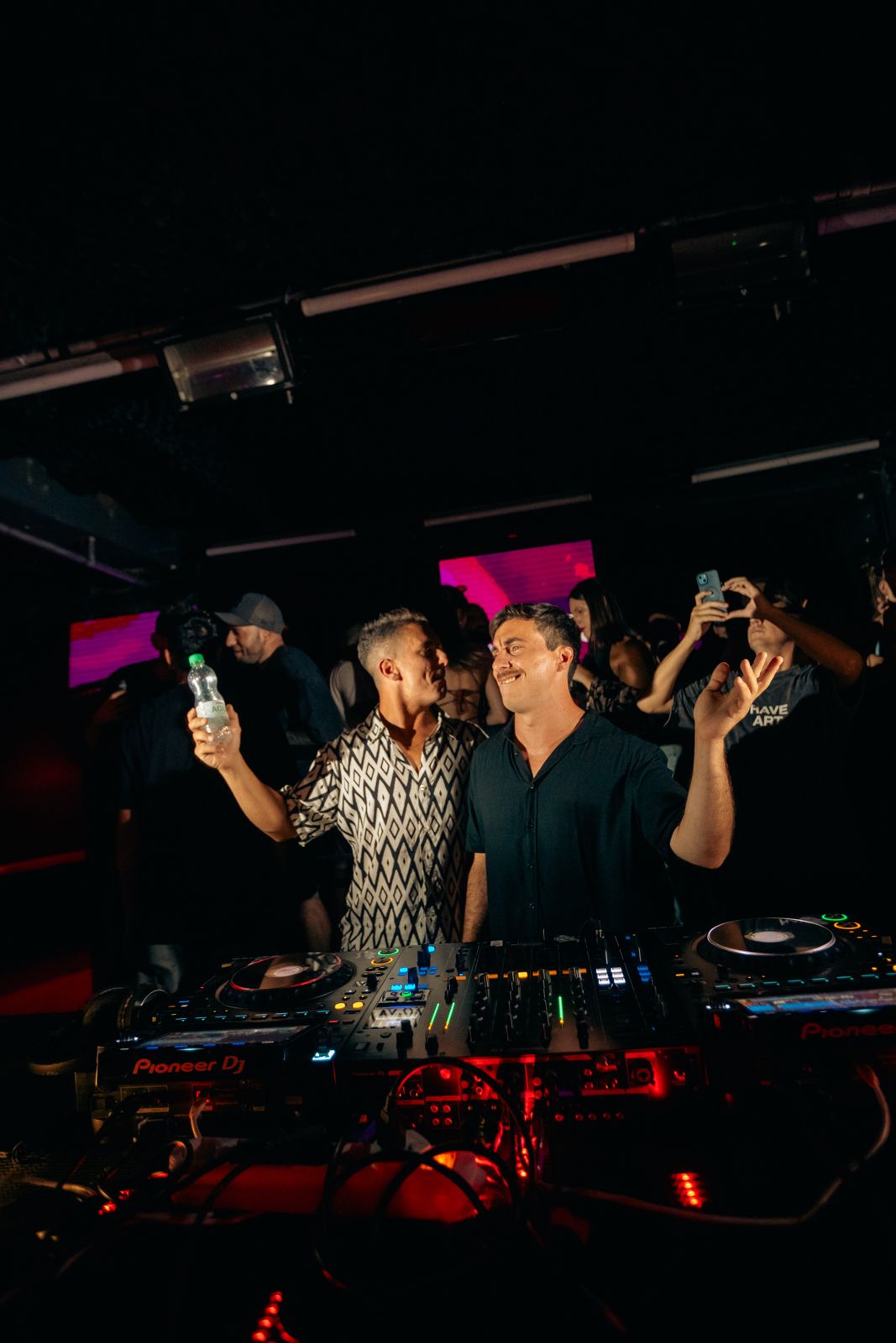 Dos artistas brindan en cabina en Tomo II
